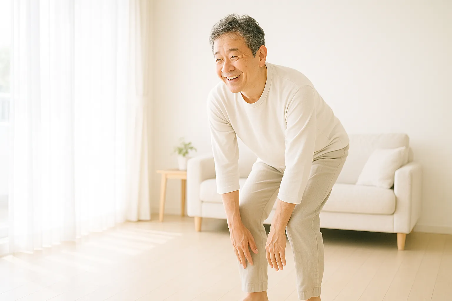 明るいリビングで朝、体を前に倒してストレッチする40〜50代の日本人男性のイメージ